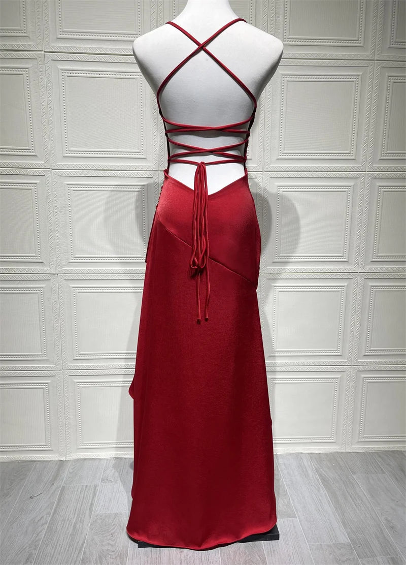 Red evening gown on a mannequin against a white paneled wall.
