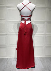 Red evening gown on a mannequin against a white paneled wall.