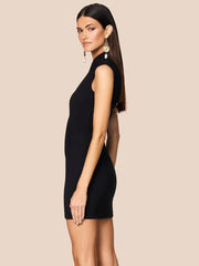 Woman wearing a black sleeveless dress against a beige background