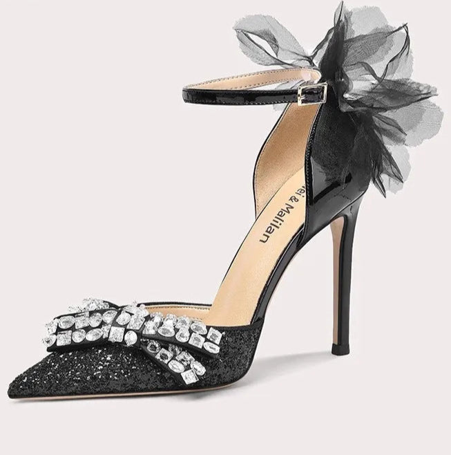 Black high-heeled shoe with decorative elements on a white background