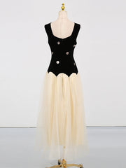 Black bodice with floral details and beige skirt on a mannequin against a white background
