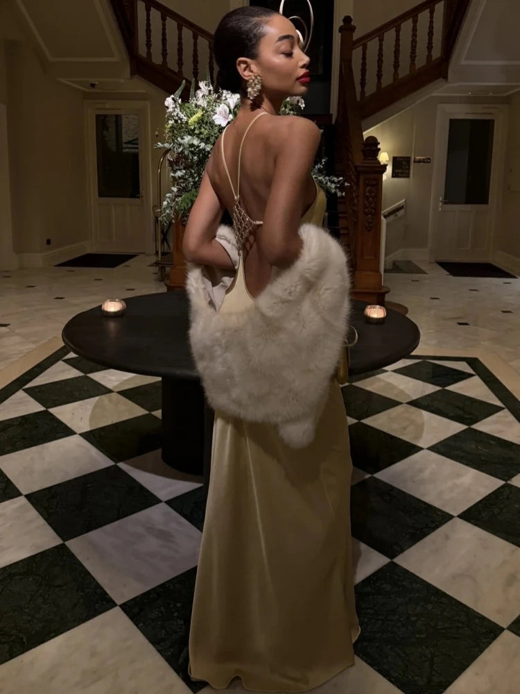 Yellow halter neck backless gown with diamond buckle detail and fur stole