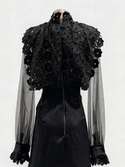 Black lace top with sheer sleeves on a mannequin against a white background