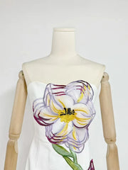 Mannequin wearing a dress with a floral design on a plain background
