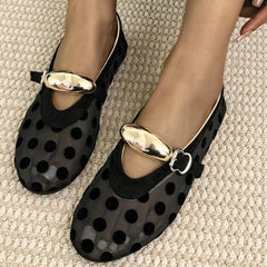Overhead view of black polka dot mesh ballet flats with gold buckle straps.