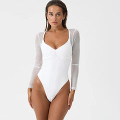 Woman wearing a white bodysuit with sheer sleeves on a light gray background