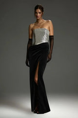 Model wearing a strapless sequined bodice and velvet maxi skirt with a high slit and gloves