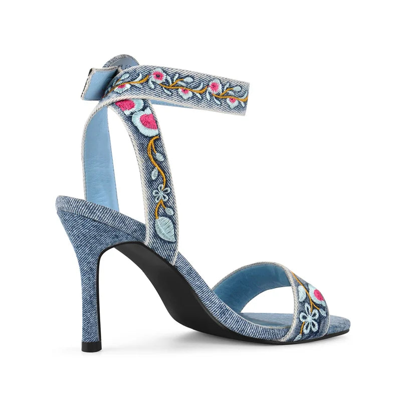 Close-up of floral embroidery on denim stiletto sandals