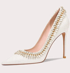 White high-heeled shoe with decorative elements on a white background