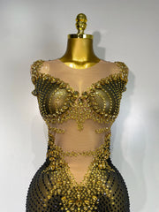 Gold beaded dress on a mannequin against a white background
