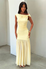 Woman wearing a light yellow dress against a plain background