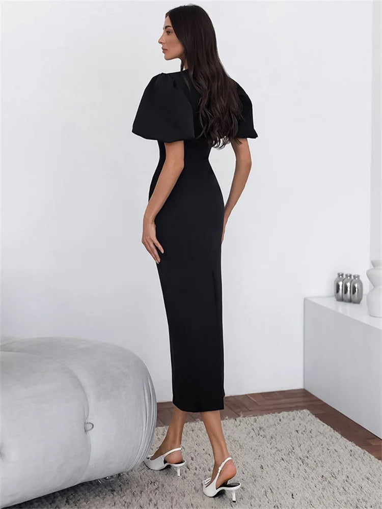 Woman wearing a black dress in a minimalistic room.