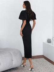 Woman wearing a black dress in a minimalistic room.
