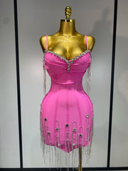 Pink dress with fringe and embellishments on a gold mannequin against a plain background