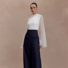 Asymmetrical draped cape sleeve blouse with sheer overlay standing pose