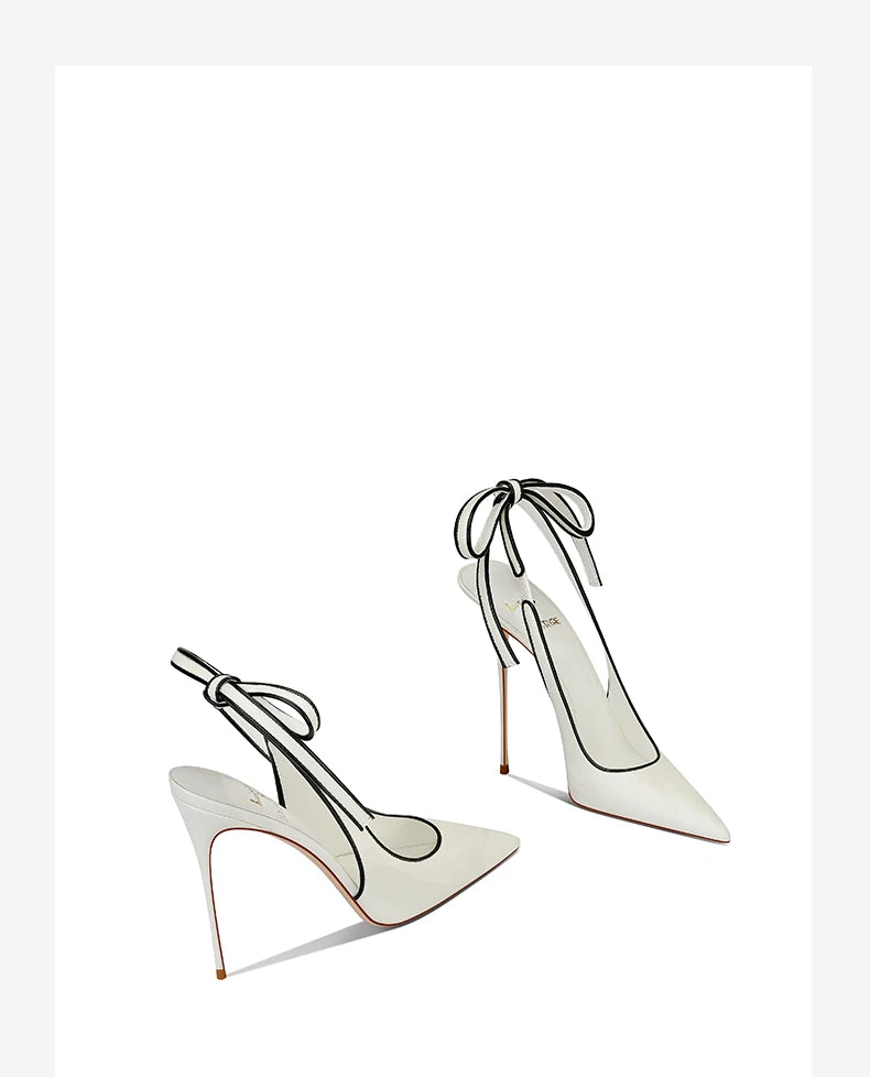 White high-heeled shoes with bow details on a white background