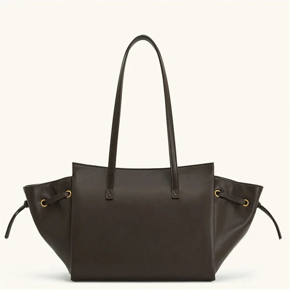 Brown leather tote bag with drawstring on a white background