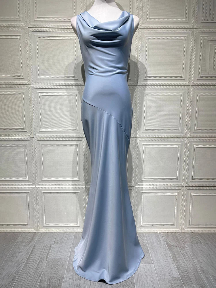 Long light blue evening gown on a mannequin against a white paneled wall.