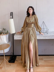 Woman in a gold dress standing indoors with a neutral background