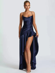 Woman wearing a navy blue evening gown with a high slit on a white background