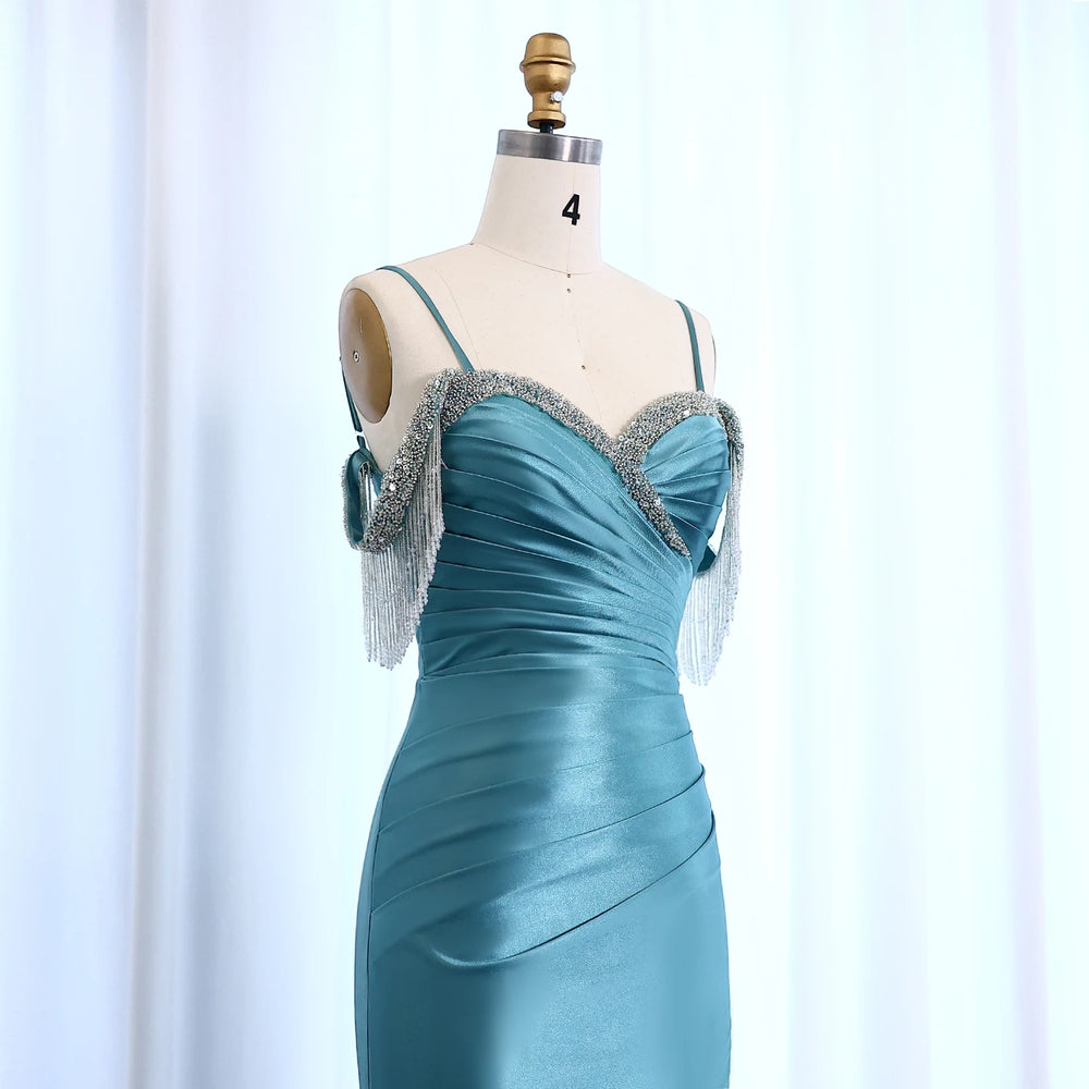Teal evening gown with silver embellishments on a mannequin against a light blue background