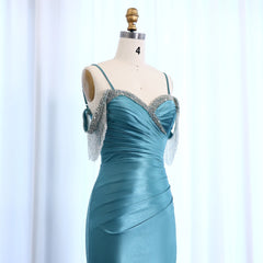 Teal evening gown with silver embellishments on a mannequin against a light blue background