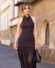 Woman wearing a brown dress standing in front of a building.