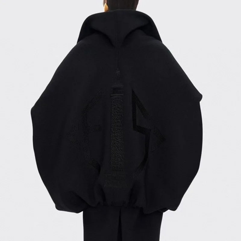 Black hoodie worn by a person on a light gray background