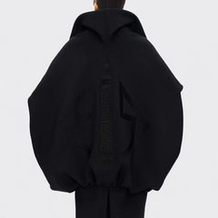 Black hoodie worn by a person on a light gray background