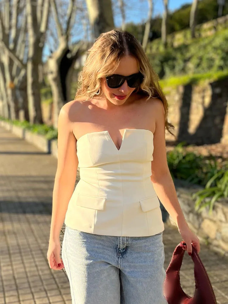 Woman wearing a strapless top and sunglasses outdoors