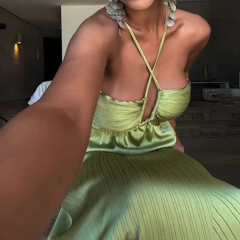 Person wearing a green dress with thin straps in an indoor setting