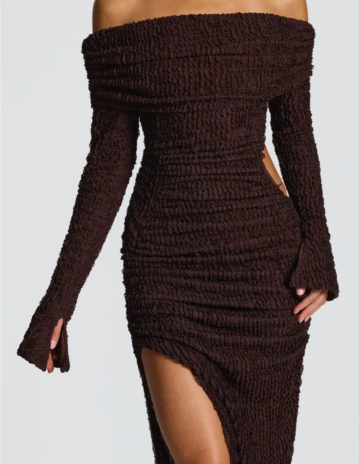 Brown ribbed knit dress with long sleeves and a high slit on a light gray background