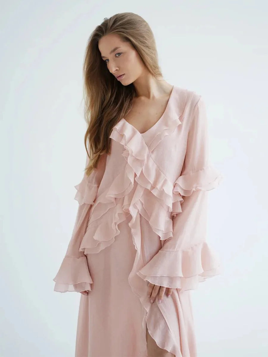 Woman wearing a light pink ruffled dress against a white background