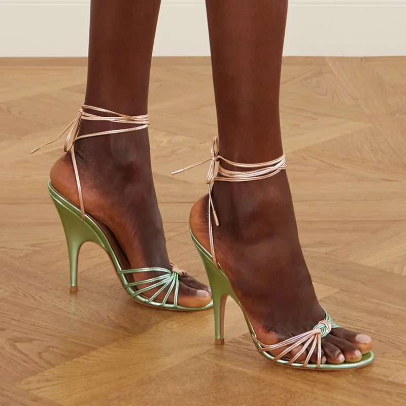 Close-up of strappy pointed toe thin heel ankle wrap sandals on a foot.