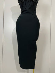 Black dress with beaded top on a mannequin against a white wall
