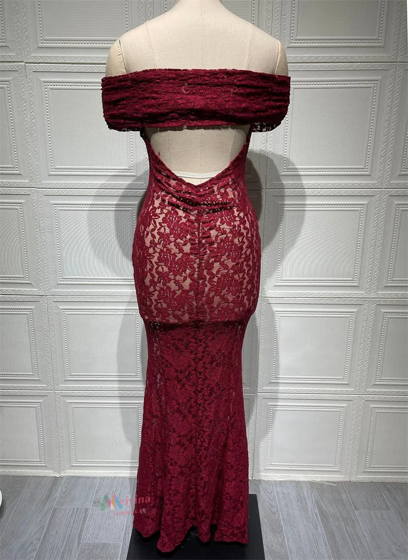 Red lace dress on a mannequin against a white paneled wall.