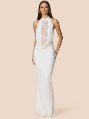 Woman wearing a white halter neck gown with lace detailing on a beige background