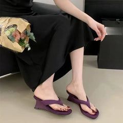Woman wearing purple wedge flip-flop sandals