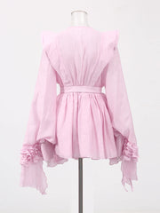 Pink blouse with ruffled sleeves on a mannequin against a white background