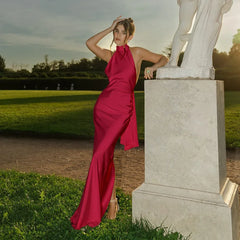 Woman in a pink dress standing next to a statue in a park