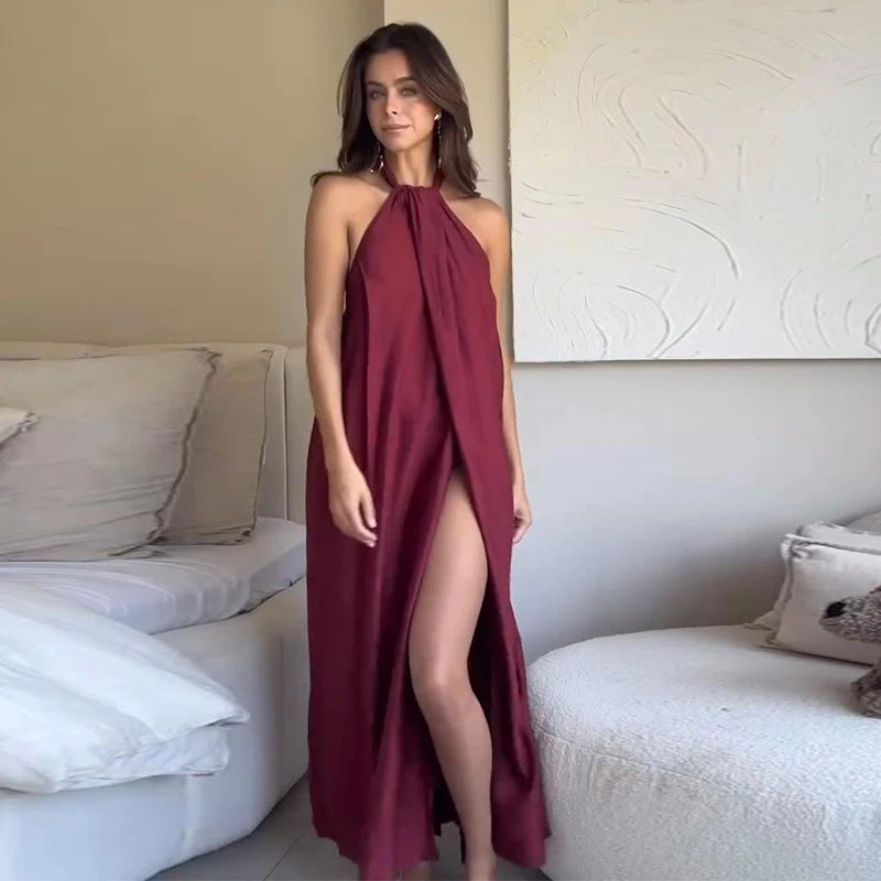 Woman in a burgundy halter neck dress standing in a living room.