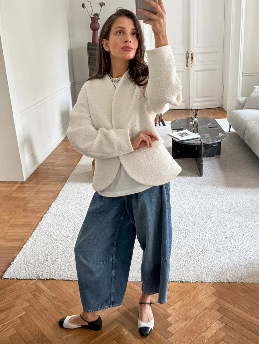 Woman taking a selfie in a stylish outfit in a modern living room.