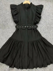 Black dress with ruffled sleeves and a belt on a gray background