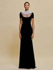 Black evening gown with sheer neckline on a beige background