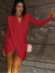 Woman in a red dress standing against a wooden wall