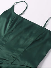 Green satin dress with thin straps on a white background
