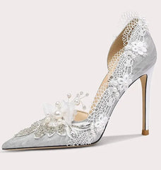 High-heeled shoe with lace and pearl details on a white background