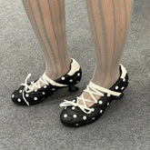 Black polka dot round toe Mary Jane heels with white cross lacing.