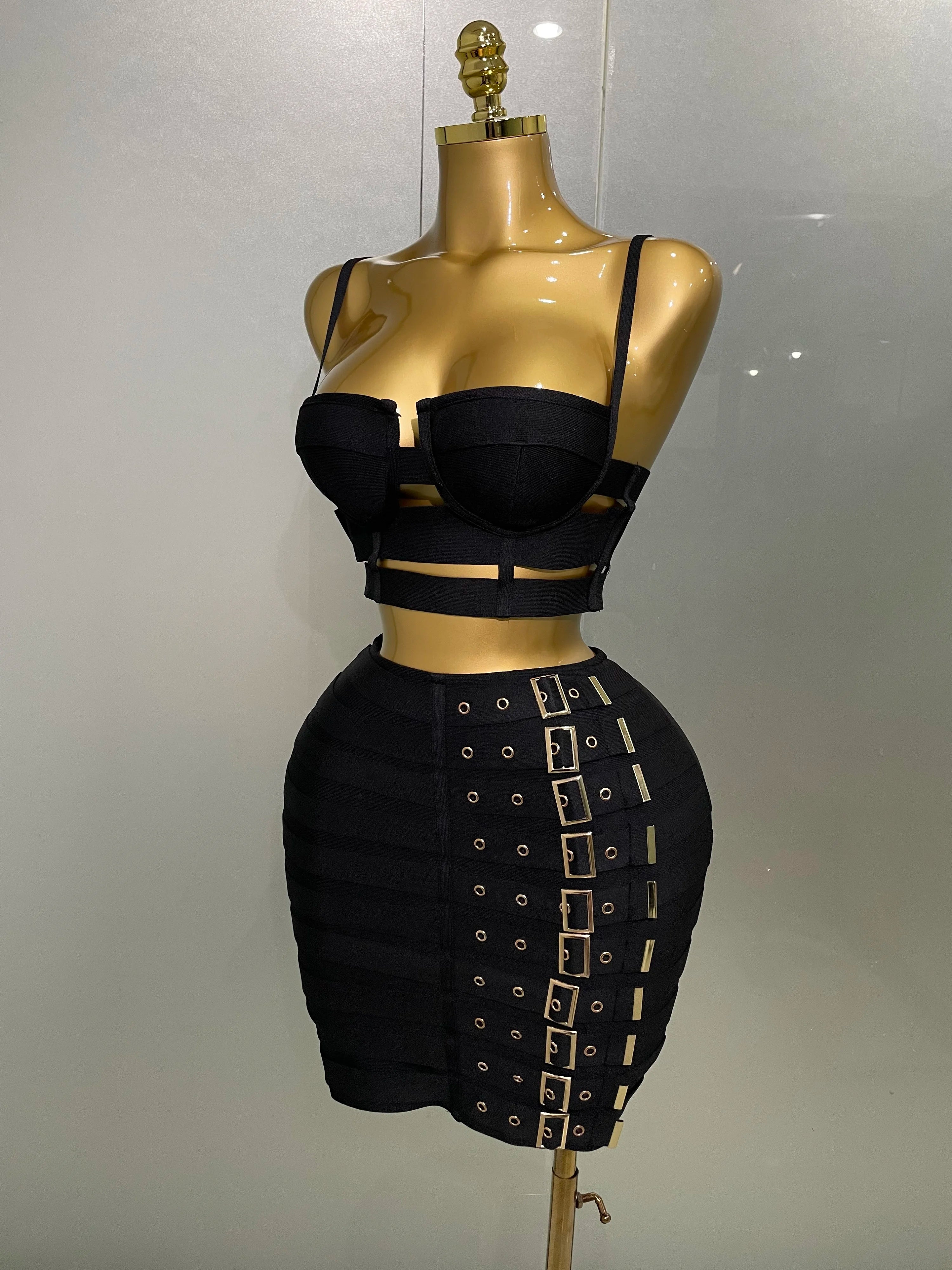 Black crop top and skirt set on a mannequin against a plain background