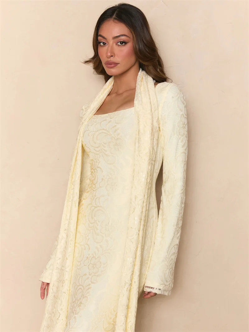 Woman wearing a light yellow embroidered traditional outfit against a beige background